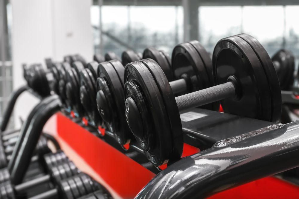 A long rack of dumbbells in a row, representing the number of choices in front of you at the gym