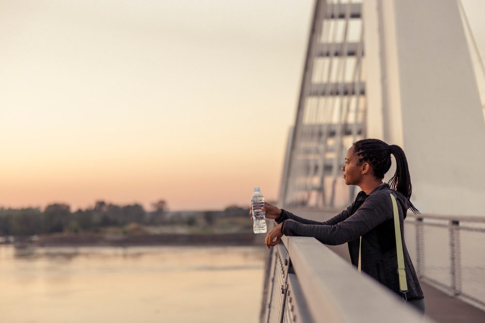 A person pausing during an early morning or evening walk, training whenever their schedule allows