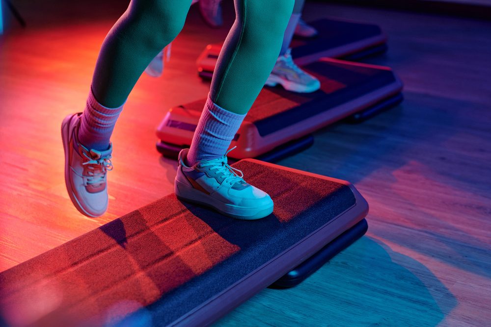 A person's feet on a raised step platform during a lower-body exercise