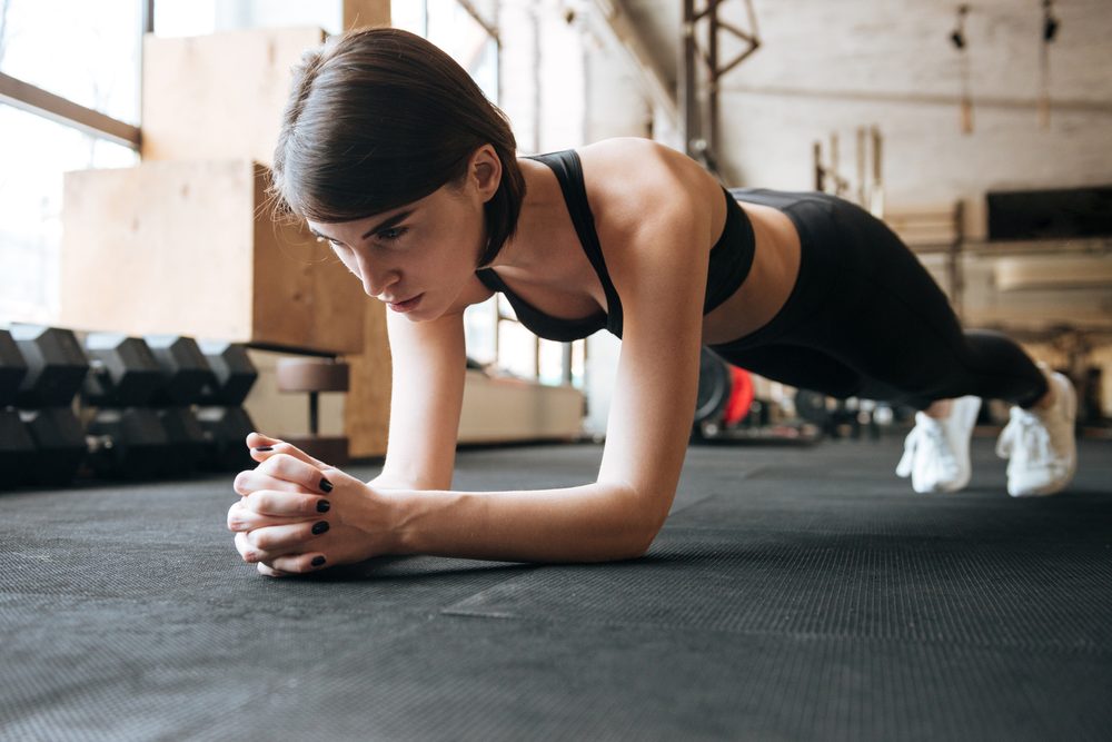 A woman holding a plank with engaged core tension