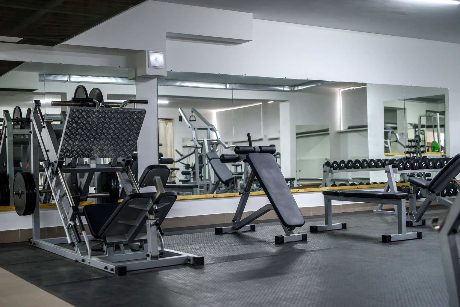 A well-organized gym floor with equipment arranged in close proximity