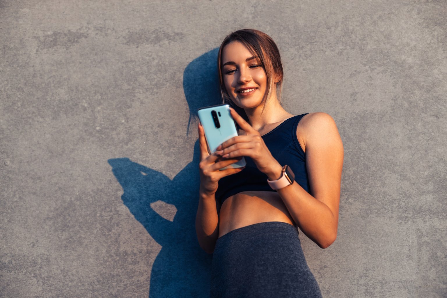 A woman pausing to check her phone, deciding what to do before starting her workout