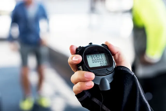 Hand holding a stopwatch during a timed workout
