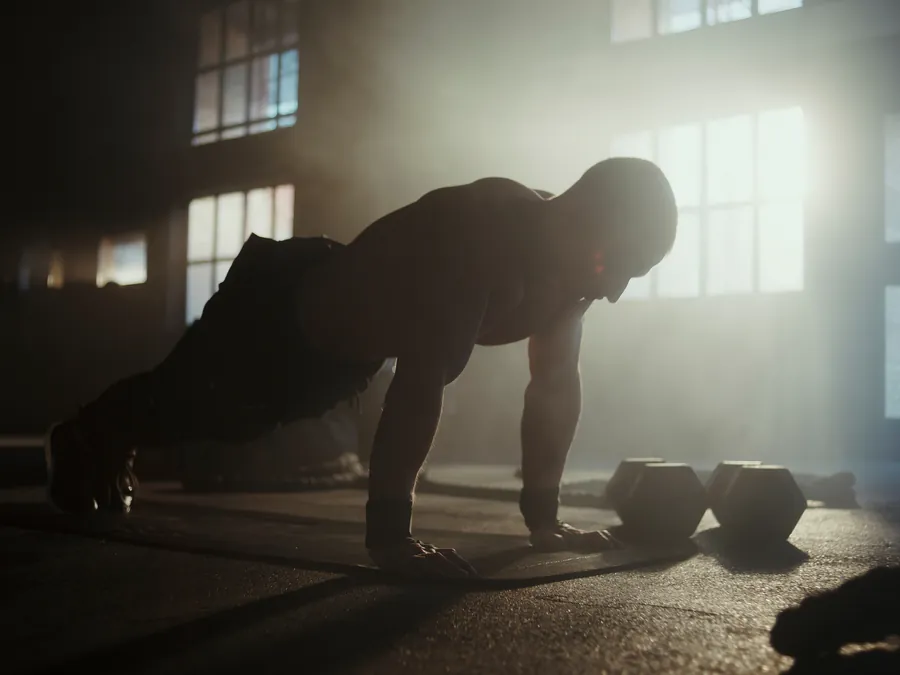 Athlete training with intense focus in a dark gym